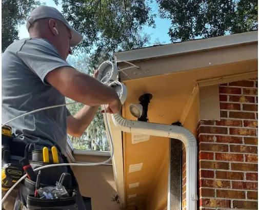 Technician installing a home security system on a Dallas house