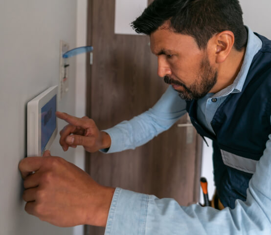 Technician programming modern business alarm system in Dallas