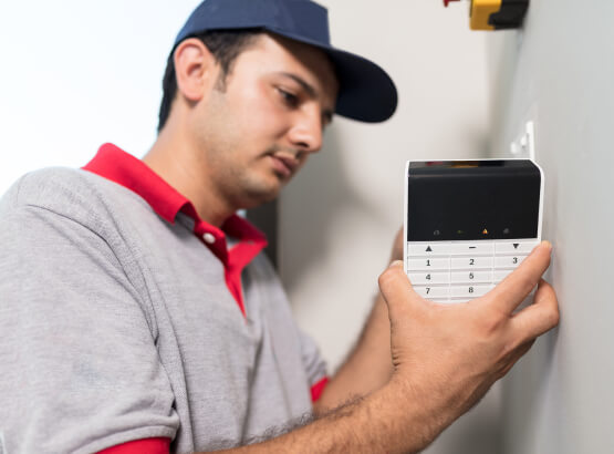 fort-worth-commercial-alarm-keypad-installation-img Technician installing a commercial alarm system keypad in Fort Worth