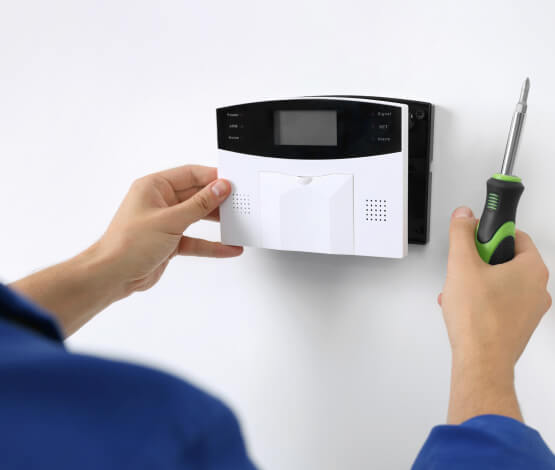 Technician installing a commercial alarm system for an Irving business