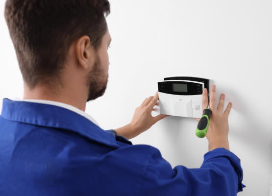 technician-installing-business-alarm-system-panel-plano-image Technician installing a business alarm system panel in Plano