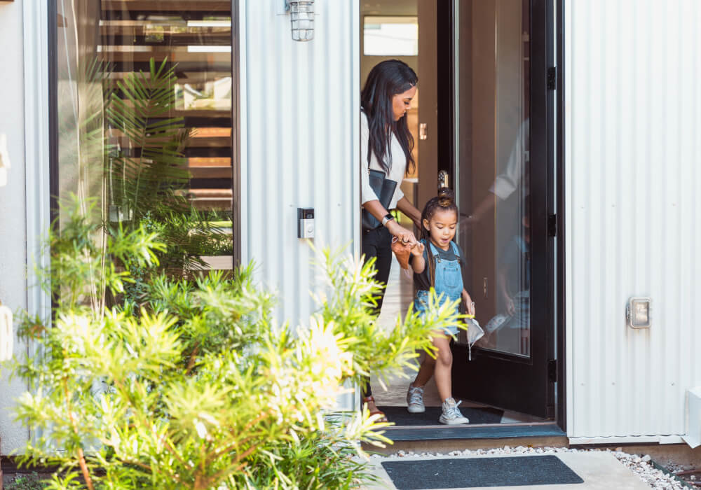 Parent and child at a secured daycare entry door